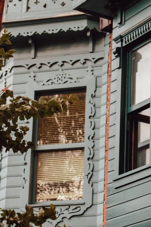 Ornate Victorian-era wooden sash window with original wavy glass in a historic Nevada City California home