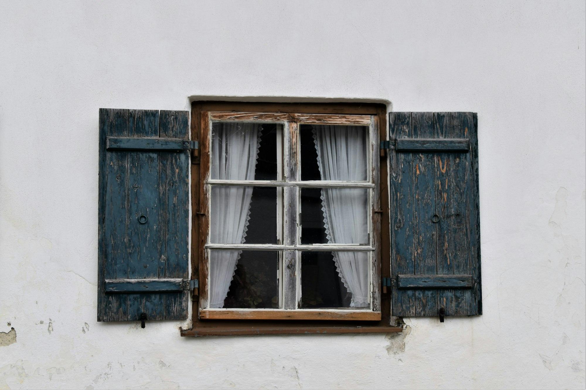 Historic wood-frame window on an older home — illustrating the original single-pane sash where vacuum insulated glass (VIG) retrofit applies in Colfax and Sierra foothill historic districts